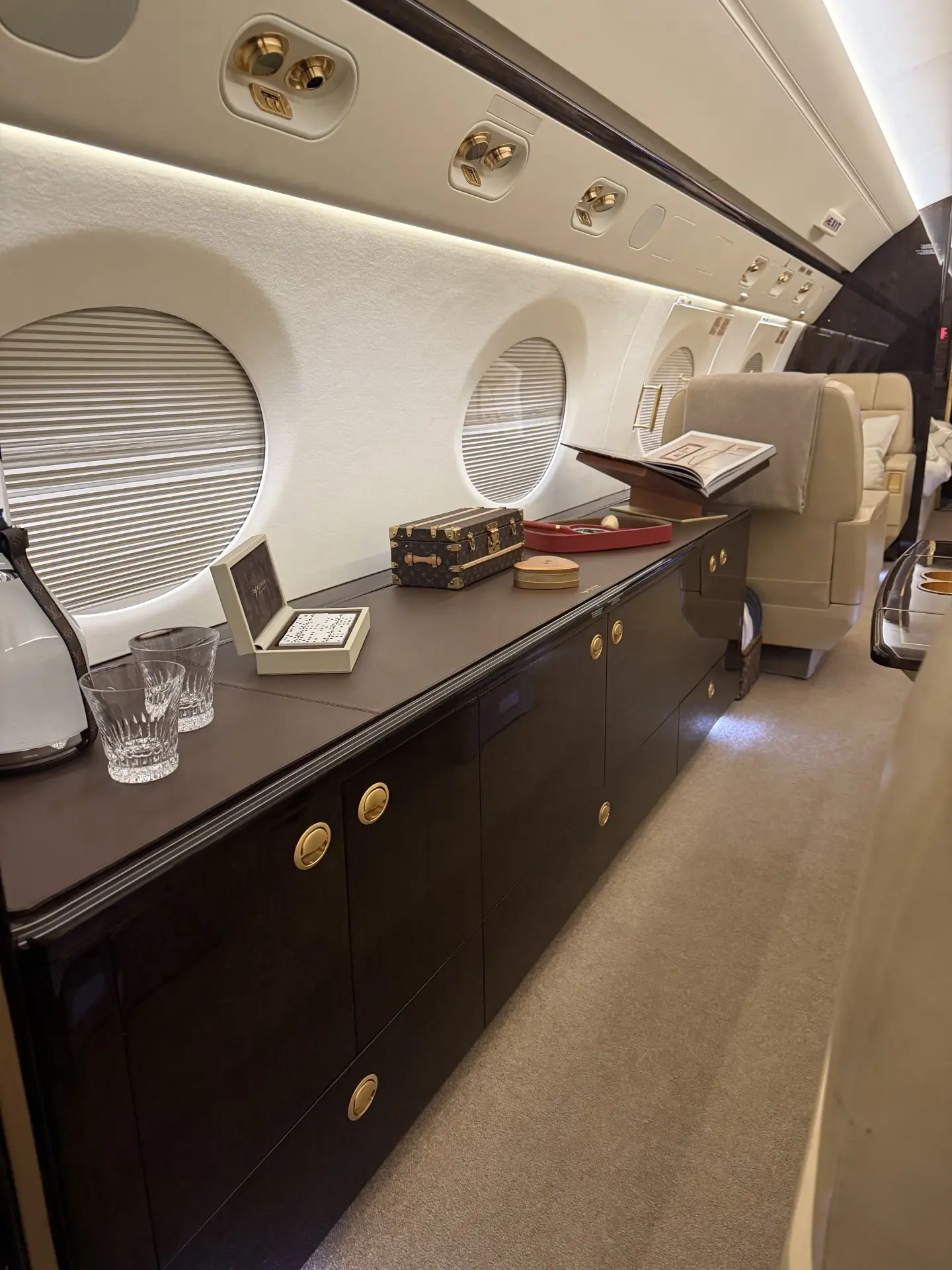 Polished credenza and cabinetry inside a large-cabin business jet