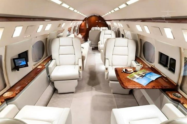 Spacious Gulfstream cabin interior with cream leather seating and polished wood trim
